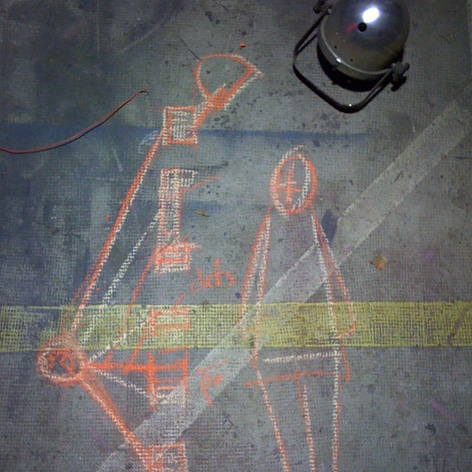Projet de luminaire avec silhouette, dessiné à la craie sur le sol de l’atelier