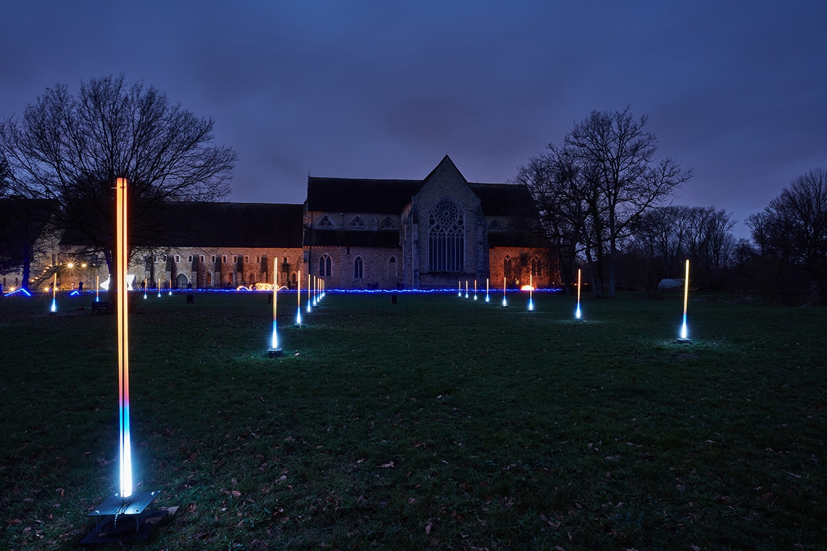 Lointains, pièce d’art contemporain composé de lignes verticales LED, dans le parc d’une abbaye, la nuit