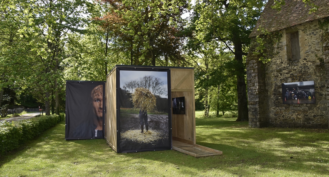 Grandes photos présentées sur des modules d’exposition en plein air composés de grands cubes en bois pour une expo photographique au milieu de la végétation