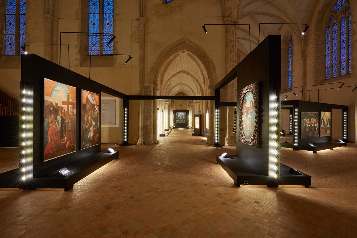 Parcours d’exposition de peintures anciennes à l’intérieur d’une abbatiale, accompagné de chants grégoriens.